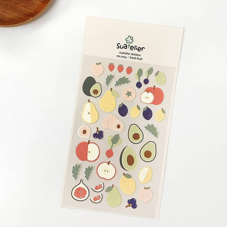 A pack of colorful fruit-themed stickers from Suatelier, featuring various shapes of fruits like avocados and oranges, displayed on a white background.