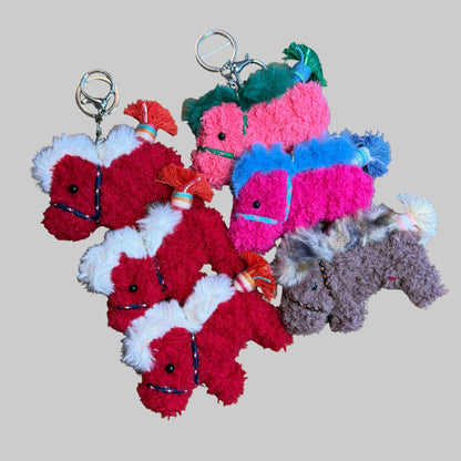 Colorful plush keychains on a wooden surface