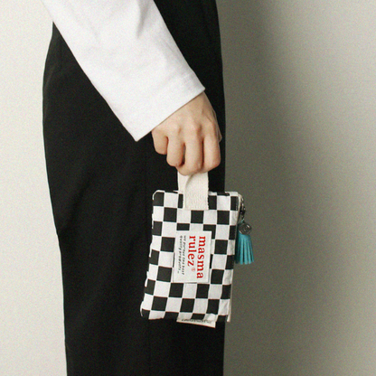 Person holding a checkered pouch with text against a neutral background