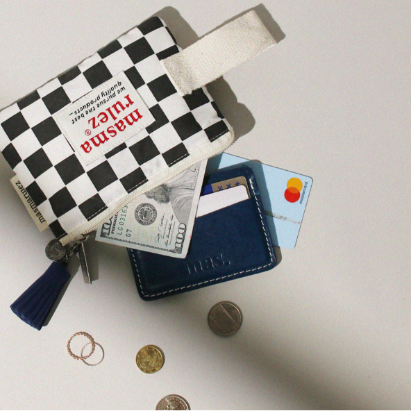 Small checkered pouch with money, cards, and coins on a light surface