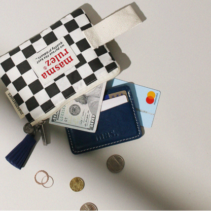 Small checkered pouch with money, cards, and coins on a light surface