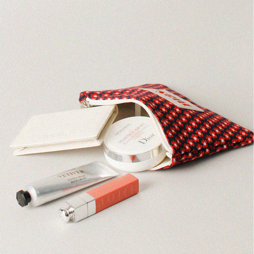 Makeup products including a compact and lip balm on a light gray background