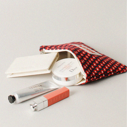 Makeup products including a compact and lip balm on a light gray background