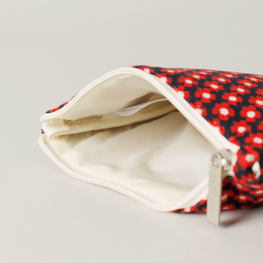 Red and black patterned pouch with a white interior on a light gray background