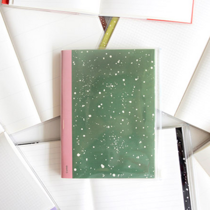 Green notebook with pink edge on a white background