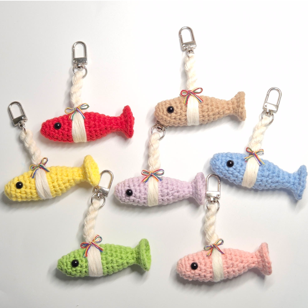 Set of colorful crocheted fish keychains on a white background