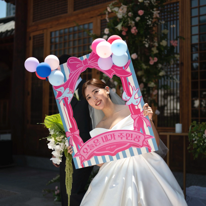 Woman in a wedding dress holding a decorative photo frame with balloons.
it's my day. celebration, birthday