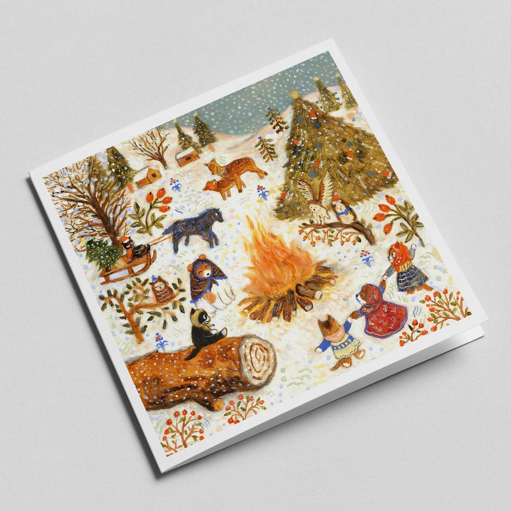 Notebook with a winter forest design featuring animals and a fire on the cover.