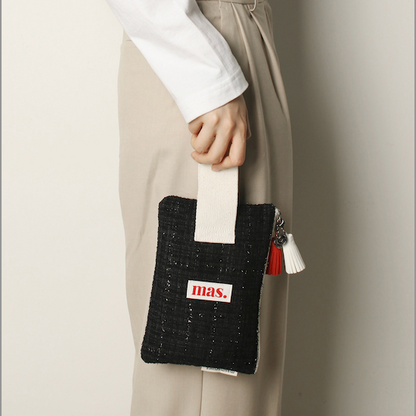 Person holding a black clutch with 'bias' branding against a neutral background